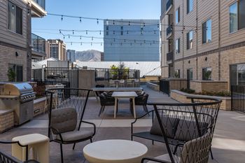 A patio with a table and chairs is surrounded by buildings.